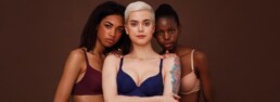 tres mujeres de distintos colores de piel miran a cámara